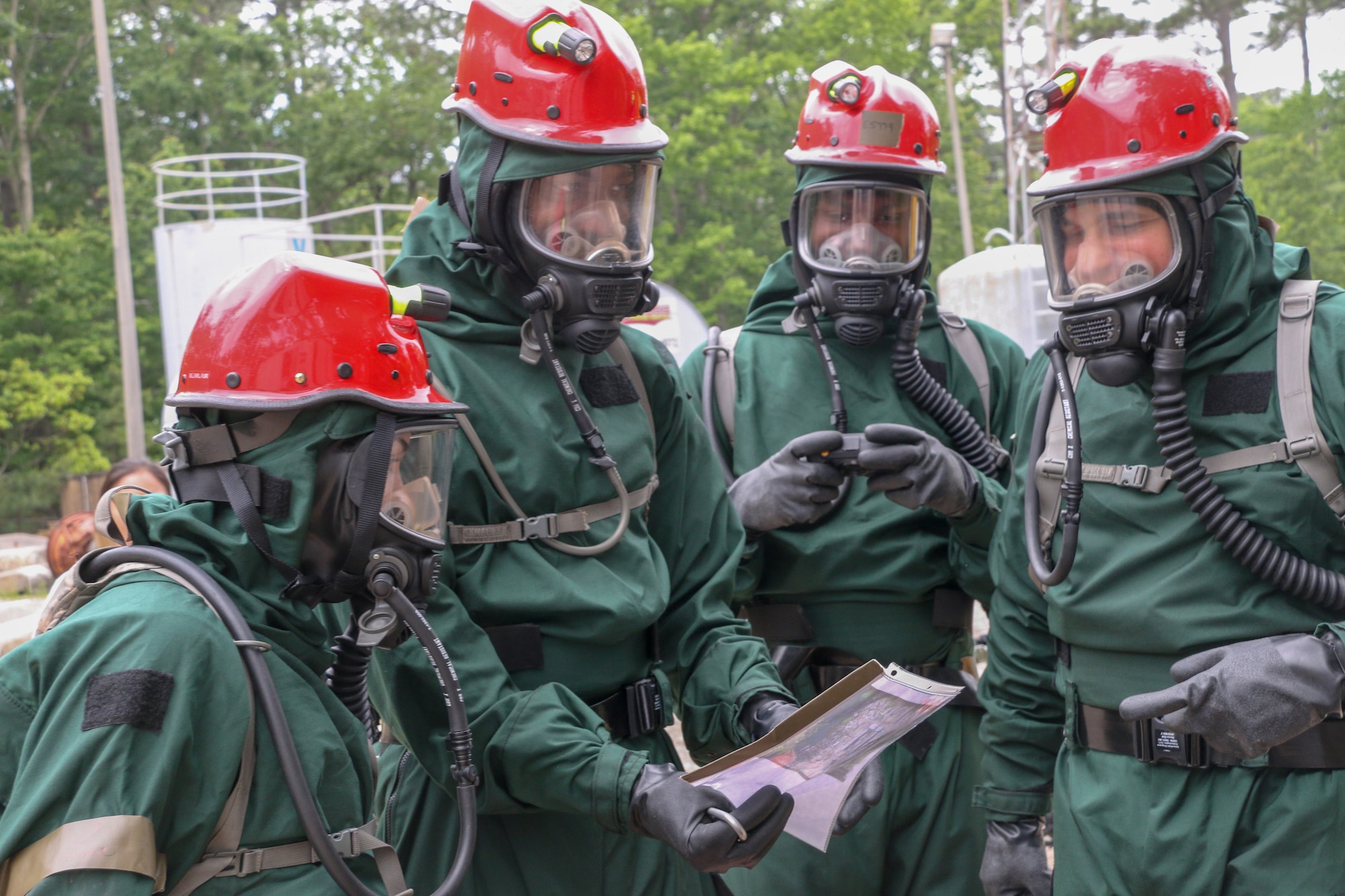 Members of the 113th Force Support Squadron, District of Columbia Air National Guard review a grid map before search and extraction during a mass casualty and CBRNE response training exercise at Virginia Beach Fire Training Center, May 21, 2023. Eleven members of FSS comprise a nationally-certified Fatality Search and Recovery Team (FSRT) responsible for urban search and rescue, mass casualty decontamination, and other federal and state disaster response. (National Guard photo by A.J. Coyne)