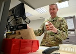 A U.S. Air Force pharmacist holds a prescription bottle in a military pharmacy.