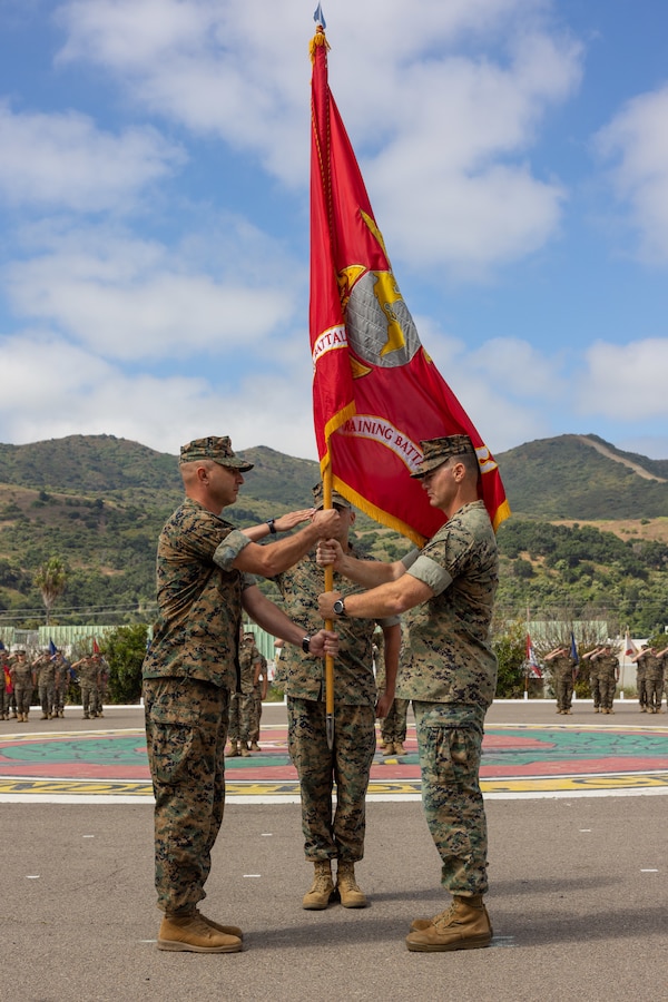 U.S. Marine Corps Lt. Col. Thomas Carey, right, the outgoing commanding officer of Advanced Infantry Training Battalion, School of Infantry -West, hands the unit colors to Lt. Col. Lonnie Wilson the incoming commanding officer, during a change of command ceremony on Marine Corps Base Camp Pendleton, California, July 7, 2023. AITB, SOI-West, trains, coaches, and qualifies entry-level Marines and Sailors in reconnaissance and advanced infantry skills to fight and win in current and future operating environments. (U.S. Marine Corps photo by Sgt. Andrew Cortez)