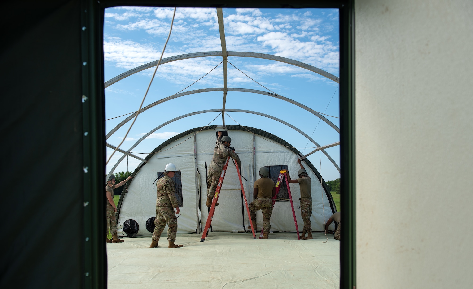 Airmen assigned to the 22nd Civil Engineer Squadron build a tent during the 22nd CES Battle of the Bulls competition July 12, 2023, at McConnell Air Force Base, Kansas. Five teams competed against each other for tent build-up; chemical, biological, radiological, and nuclear training; convoy operations; land navigation; tactical combat casualty care; defensive fighting position and general knowledge during the competition. (U.S. Air Force photo by Staff Sgt. Tryphena Mayhugh)
