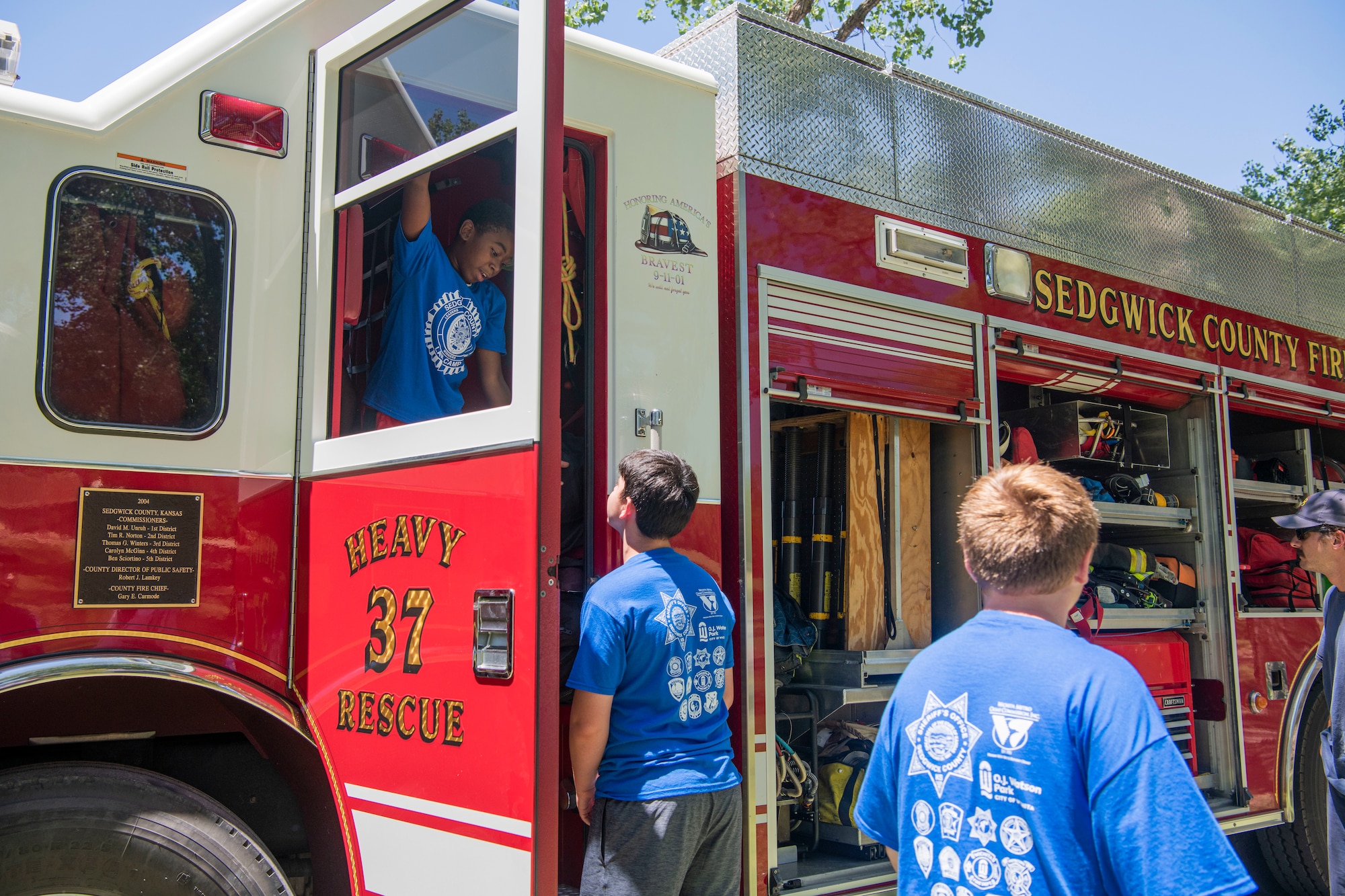 Participants at L.A.W Camp take a tour of a Fire Truck at O.J Watson Park, Wichita, Kansas July 11, 2023. A number of organizations were represented among the volunteer’s, including: the Sedgwick County Sheriff’s Office; the Wichita, Bentley and Maize Police Departments; Sedgwick County Fire Department; Kansas Air National Guard; and the Air Force Reserve’s 931st Air Refueling Wing. (U.S. Air Force Photo by Airman 1st Class Gavin Hameed)