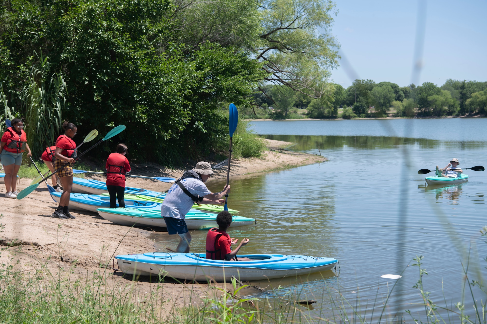 Volunteers at L.A.W Camp teach campers how to kayak at O.J Watson Park, Wichita, Kansas July 11, 2023. Camp activities included kayaking, fishing, golf, paddleboats, corn hole, K-9 demonstrations, volleyball, a heavy rescue demo by the county fire department, and group discussions with Wichita Police Department officers about gangs, peer pressure, and de-escalation. (U.S. Air Force Photo by Airman 1st Class Gavin Hameed)