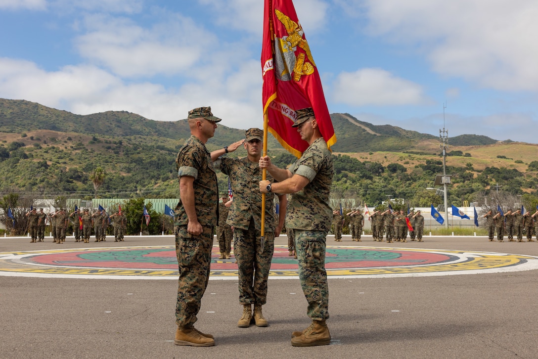 U.S. Marine Corps Lt. Col. Thomas Carey, right, the outgoing commanding officer of Advanced Infantry Training Battalion, School of Infantry -West, delivers the battalion colors to Lt. Col. Lonnie Wilson the incoming commanding officer, during a change of command ceremony on Marine Corps Base Camp Pendleton, California, July 7, 2023. AITB, SOI-West, trains, coaches, and qualifies entry-level Marines and Sailors in reconnaissance and advanced infantry skills to fight and win in current and future operating environments.  (U.S. Marine Corps photo by Sgt. Andrew Cortez)