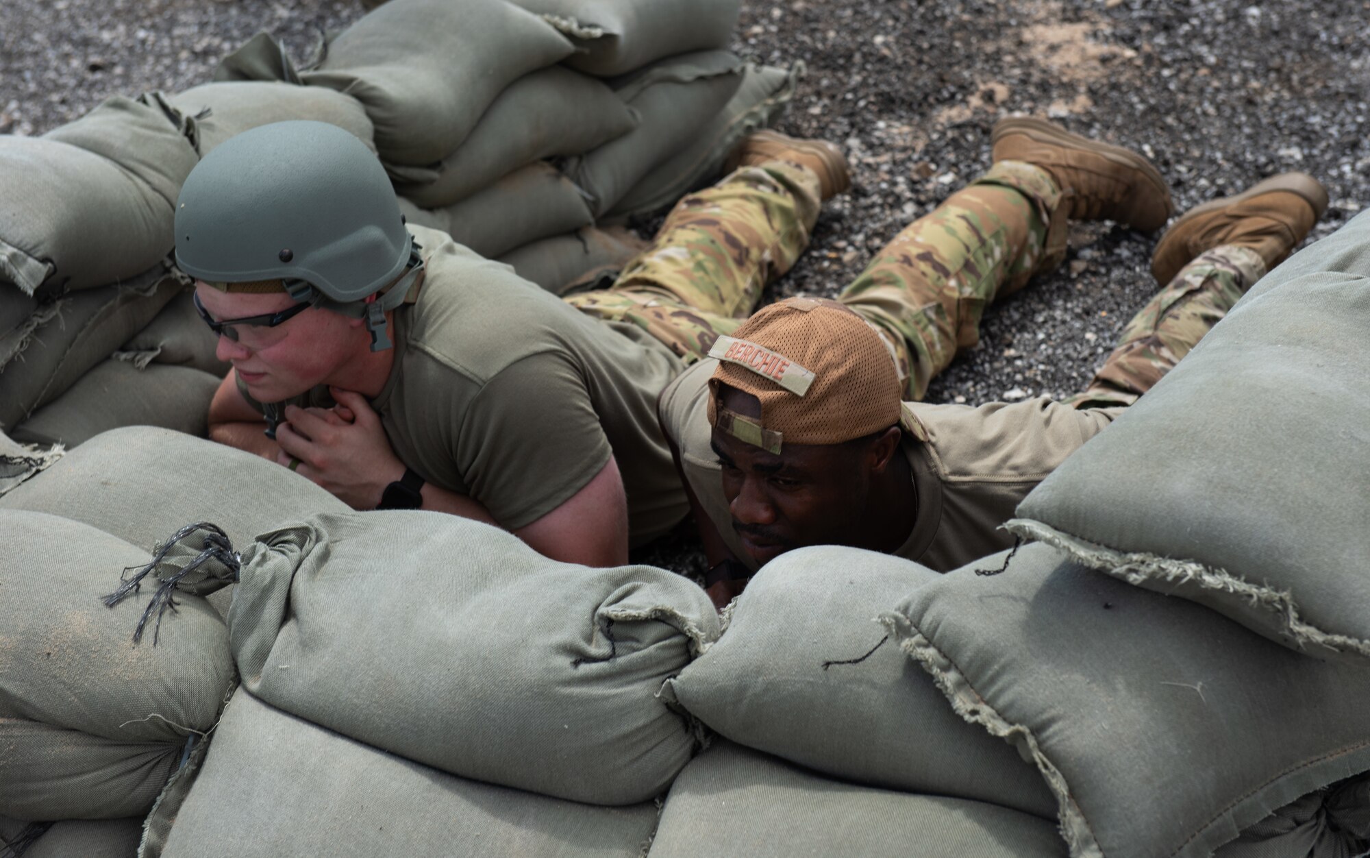 Two Airmen assigned to the 22nd Civil Engineer Squadron lay in a sandbag shelter during the 22nd CES Battle of the Bulls competition July 12, 2023, at McConnell Air Force Base, Kansas. Five teams competed against each other for tent build-up; chemical, biological, radiological, and nuclear training; convoy operations; land navigation; tactical combat casualty care; defensive fighting position and general knowledge during the competition. (U.S. Air Force photo by Staff Sgt. Tryphena Mayhugh)