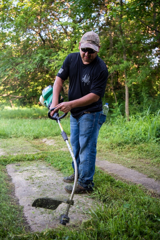 Army Staff Sgt. John Culqui, 1-210 Aviation Regiment, instructor, edges along a grave site at Elmerton Cemetery in Hampton, Virginia, July 8, 2023. Culqui was one of 52 Soldiers who volunteered for the community relations event to help maintain and preserve two of Hampton Roads’ oldest cemeteries in partnership with the Barrett-Peake Heritage Foundation’s restoration project. (U.S. Air Force photo by Abraham Essenmacher)