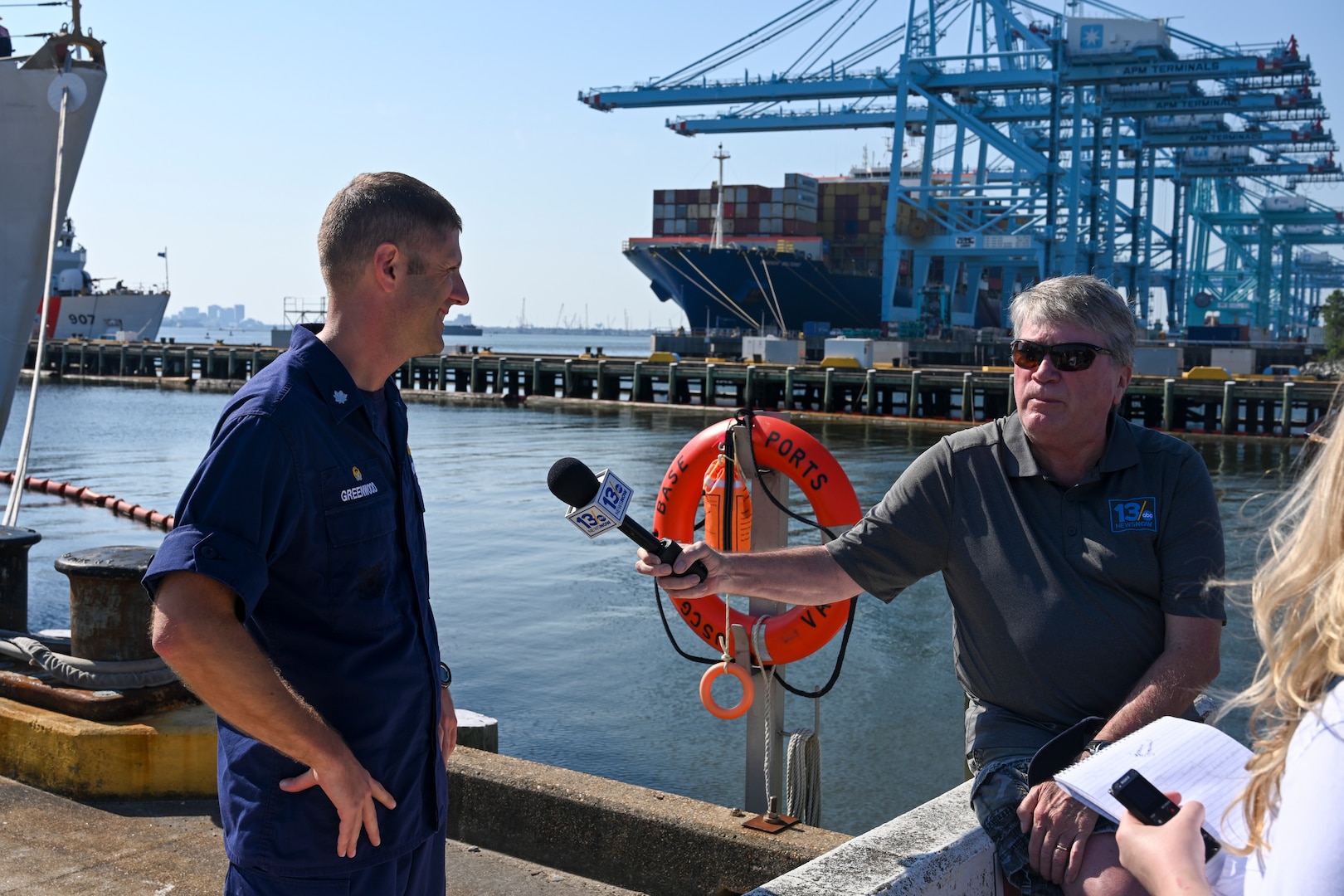 U.S. Coast Guard Cmdr. Jeremy Greenwood, left, the commanding officer of USCGC Legare (WMEC 912), speaks with Mike Gooding, right, a reporter, at the unit's return to home port, July 13, 2023, at Coast Guard Base Portsmouth. While underway, Legare’s crew conducted maritime safety and security missions while working to detect, deter and intercept unsafe and illegal maritime migration ventures bound for the United States. (U.S. Coast Guard photo by Petty Officer 3rd Class Kate Kilroy)