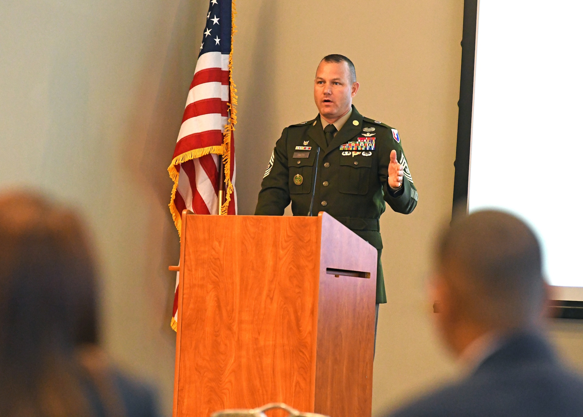 Soldier at podium in front of group of people.