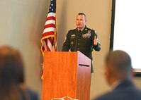 Soldier at podium in front of group of people.