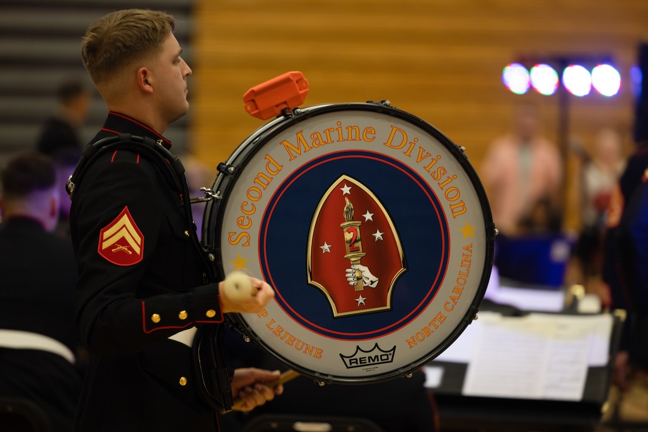 A Marine plays a drum during a performance.