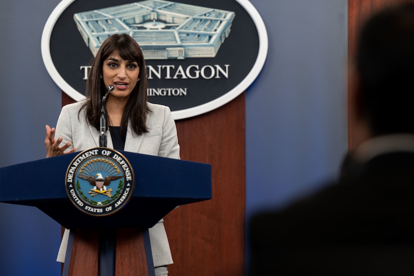 A woman speaks from a lectern.