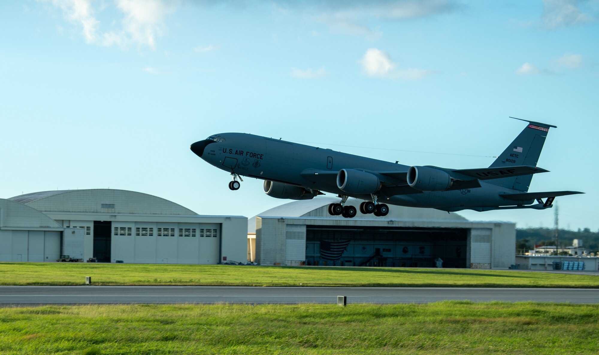 A KC-135 Stratotanker takes off from a runway after a hot-pit refuel.