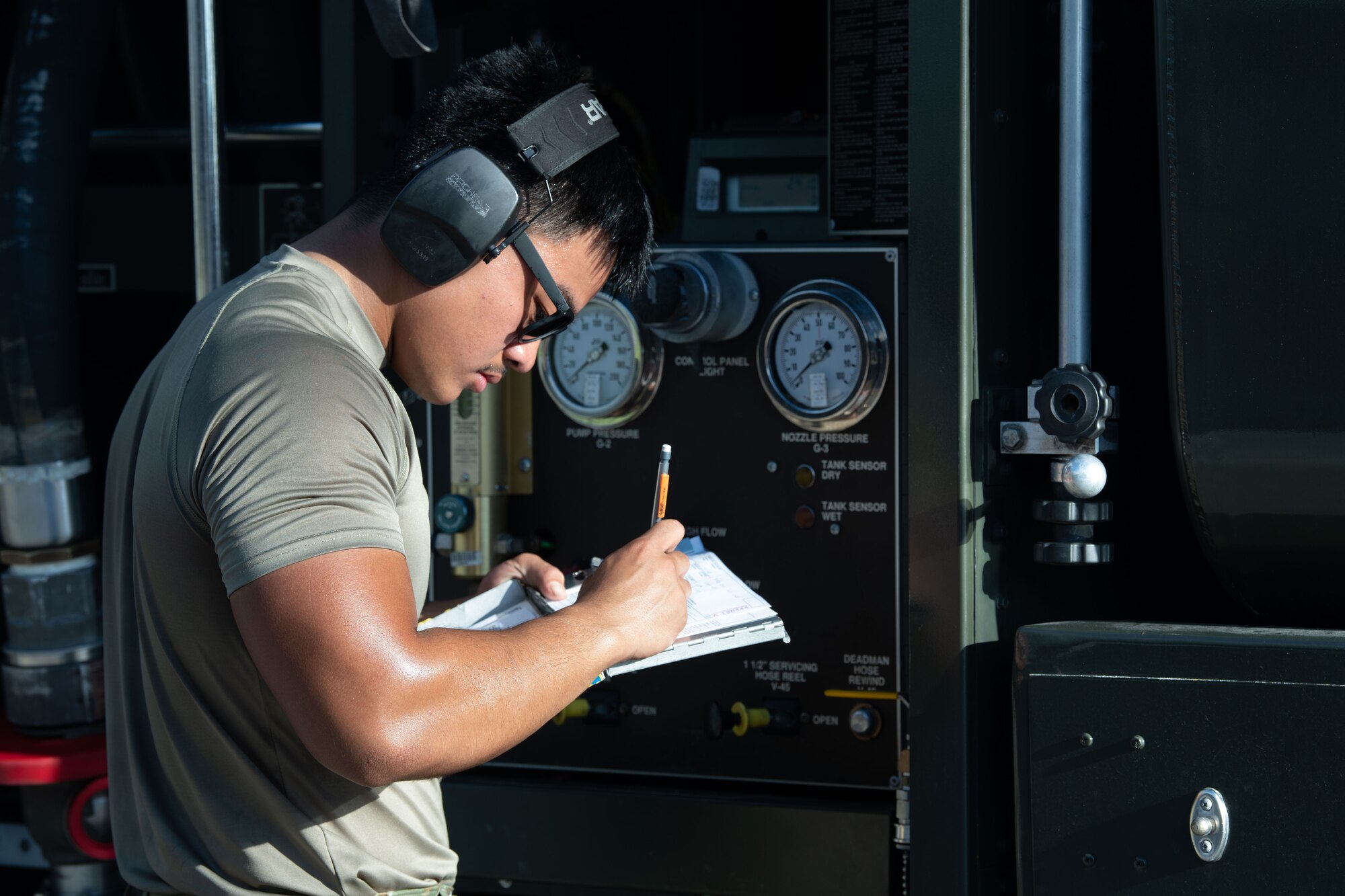 A U.S. Air Force Airman assigned to the 18th Logistics Readiness Squadron records data during a hot-pit refueling