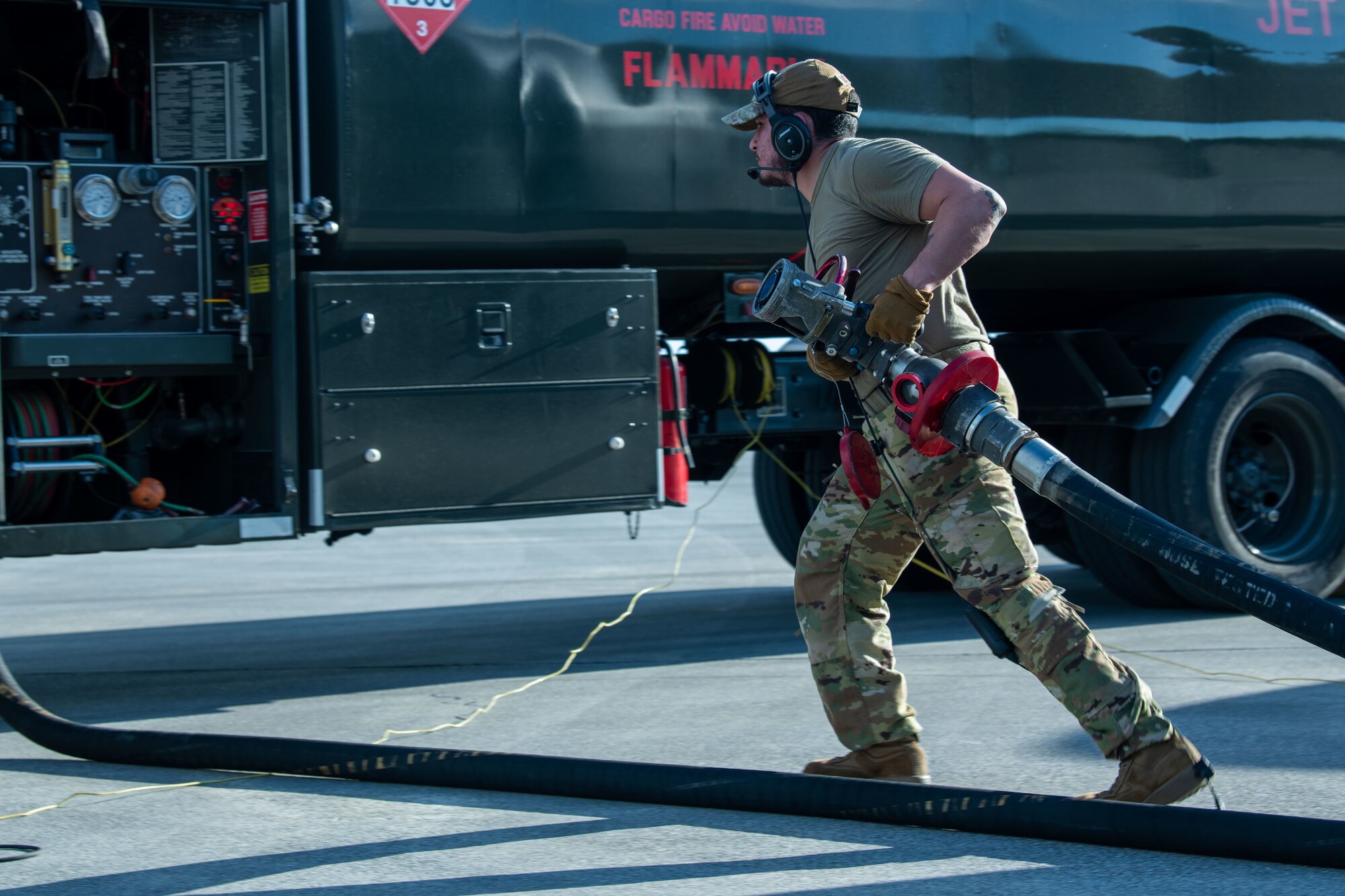 A U.S. Air Force Airman assigned to the 92nd Air Refueling Squadron removes a refueling pipe during a hot-pit refueling.