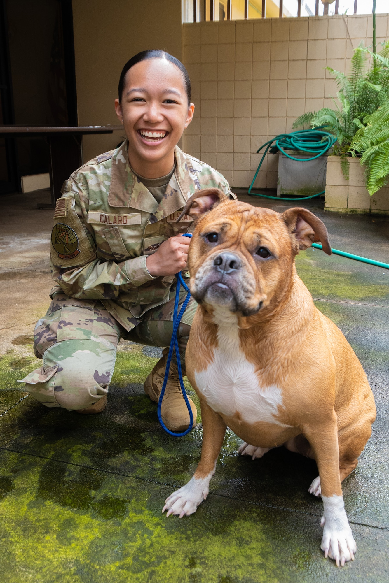U.S. Air Force Airman 1st Class Faith Calaro, 169th Air Defense Squadron surveillance technician, kneels alongside Ruby the dog on June 3, 2023 at Wheeler Army Airfield, Hawaii.