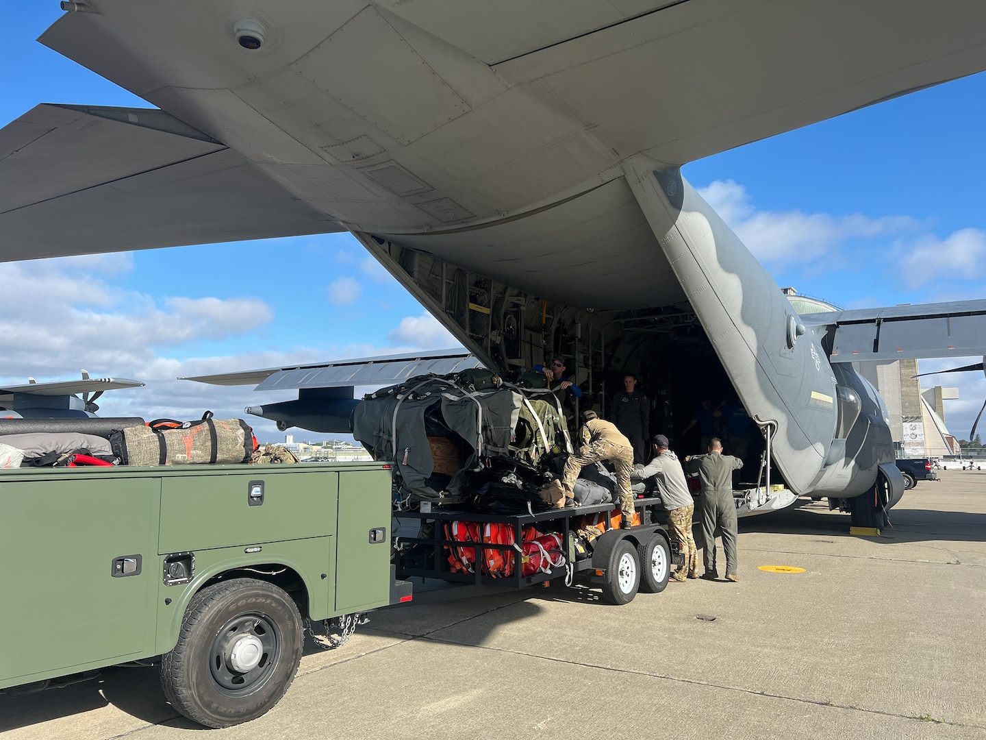 U.S. Air Force Airmen with the 129th Rescue Wing load equipment and supplies onto an HC-130J Combat King II aircraft at Moffett Air National Guard Base, California in preparation for a rescue mission, July 8, 2023.