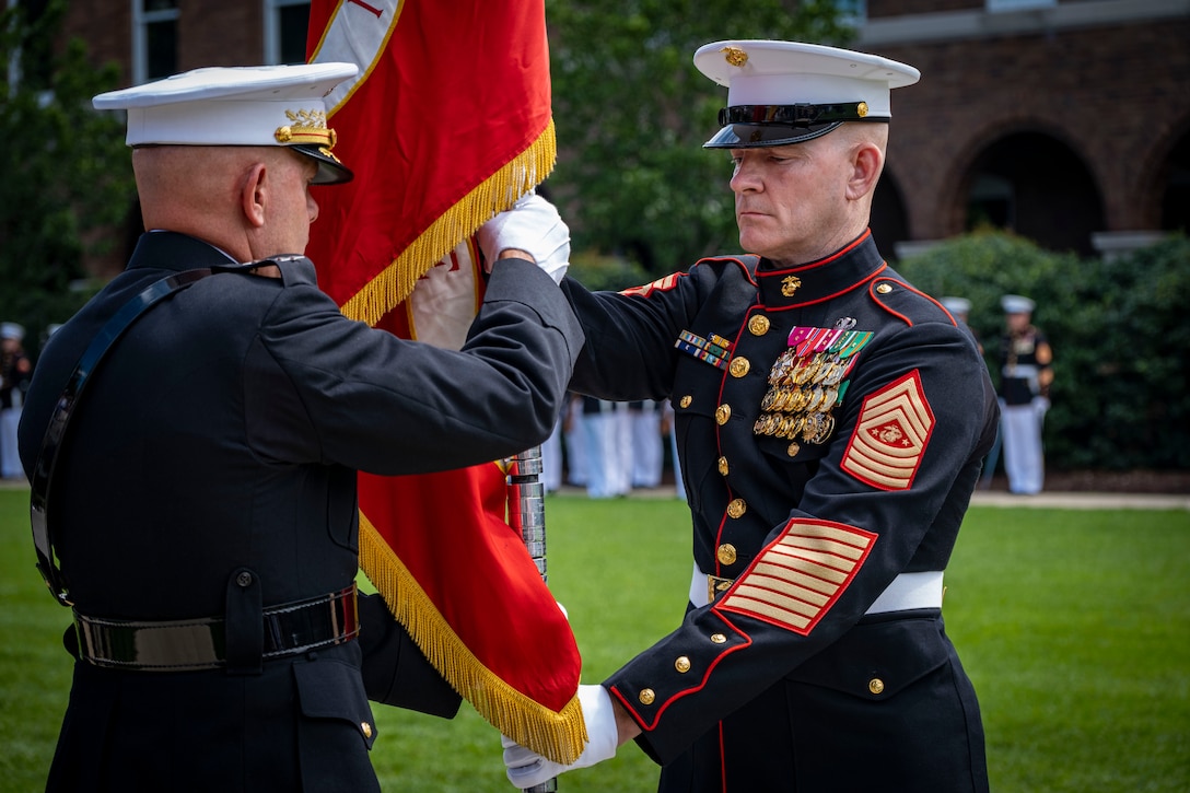 Sergeant Maj. Troy E. Black, the 19th Sergeant Maj. of the Marine Corps, passes the the battle colors to Gen. David H. Berger, the 38th Commandant of the U.S. Marine Corps, during the 38th Commandant of the Marine Corps Relinquishment of Office Ceremony at Marine Barracks Washington D.C., July 10, 2023. General David H. Berger relinquished the duties of the office of the Commandant of the Marine Corps to the Assistant Commandant, Gen. Eric M. Smith. While Gen. Smith has been nominated to be the 39th Commandant, his nomination remains pending in the Senate. General Smith will perform the duties of the Commandant until a successor is appointed, retaining the title and position of Assistant Commandant. (U.S. Marine Corps photo by Cpl. Mark A. Morales)