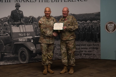 Two men in U.S. Army uniform pose for photo.