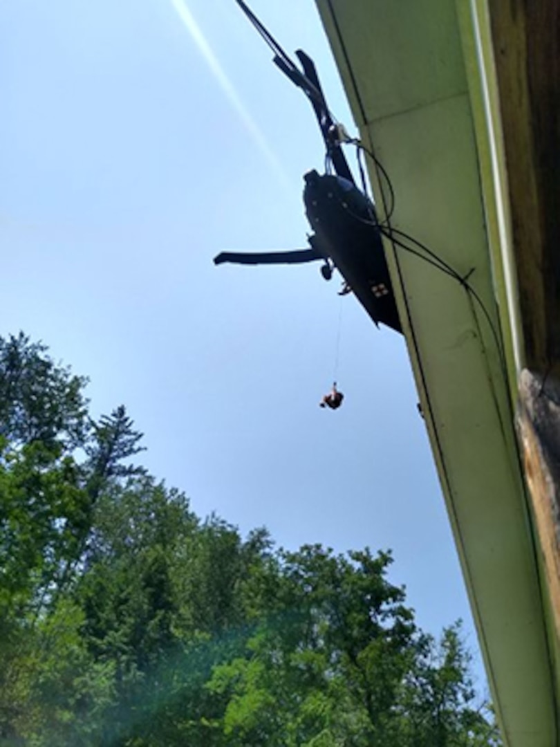 One of three people are rescued from their residence by a NHARNG Black Hawk crew July 11 in Berlin, Vermont.