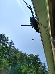 One of three people are rescued from their residence by a NHARNG Black Hawk crew July 11 in Berlin, Vermont.