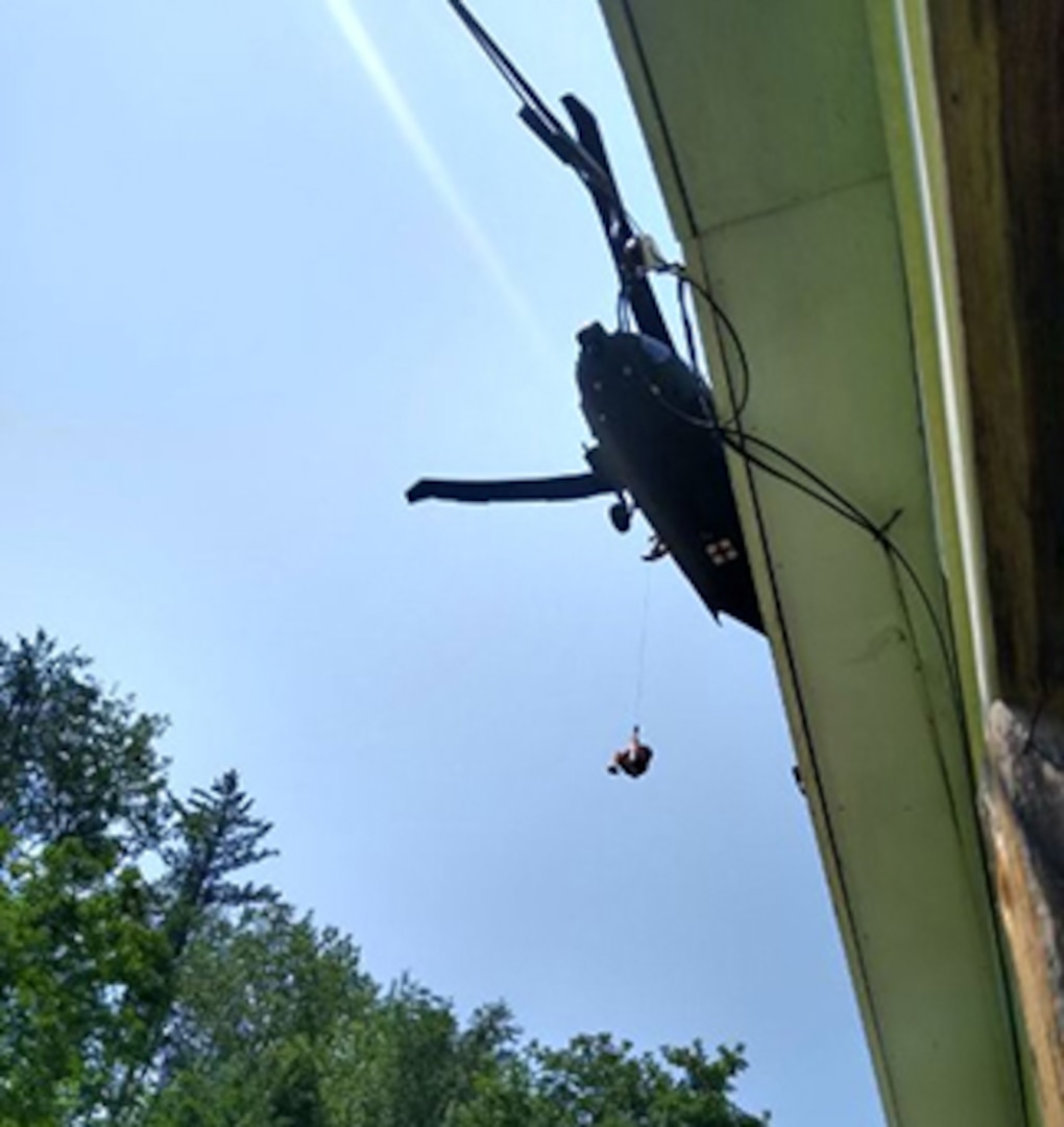One of three people are rescued from their residence by a NHARNG Black Hawk crew July 11 in Berlin, Vermont.