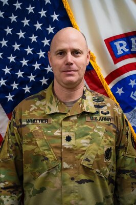 Male Soldier posed in front of American flag and USAREC flag.