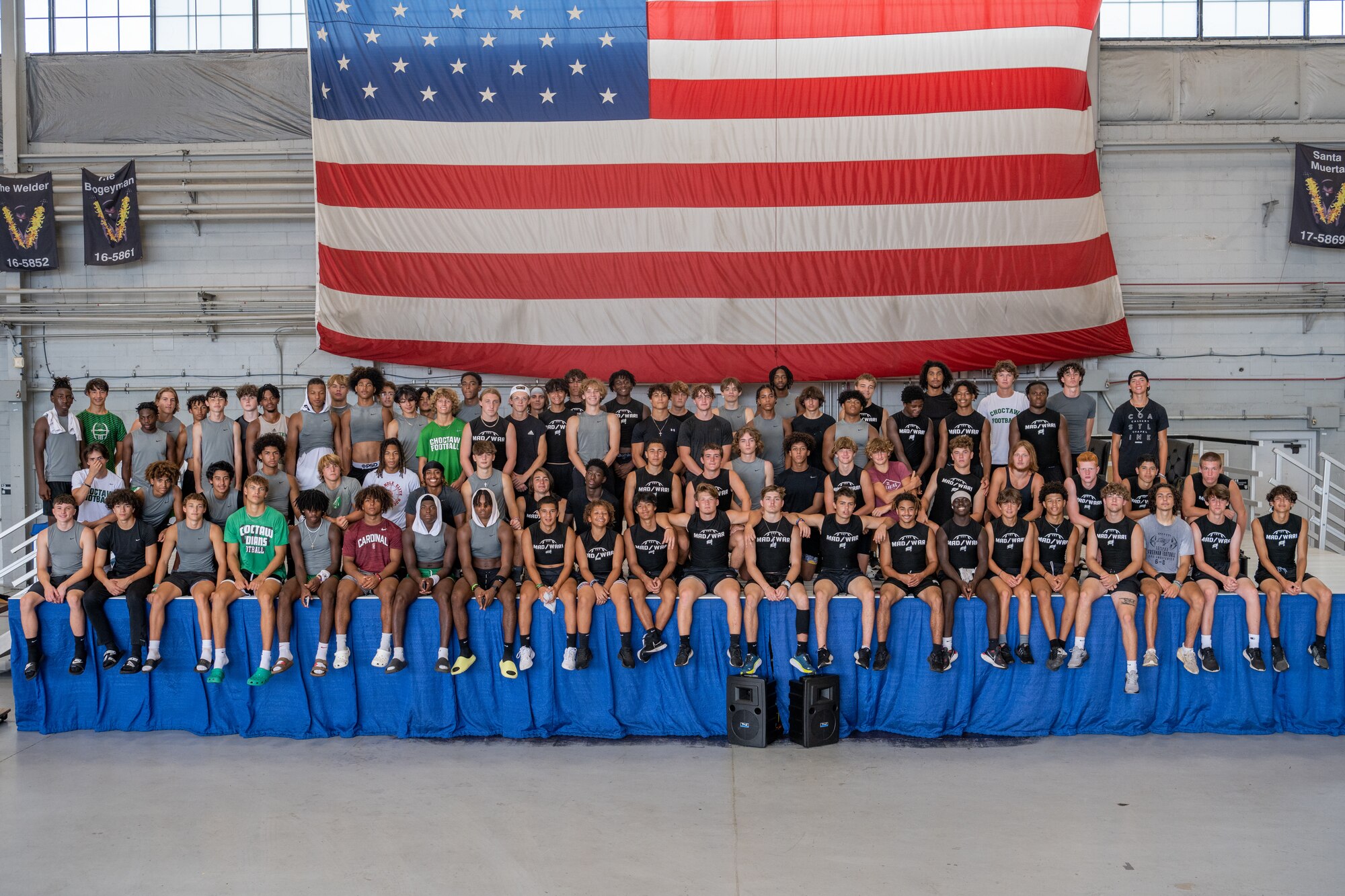 Students from Navarre High school and Choctawhatchee High School pose for a group photo at the Commando Hanger at Hurlburt Field, Florida, July 13, 2023.  Over 100 football players and coaches from Navarre High School and Choctawhatchee High School visited Hurlburt Field to learn more about Air Force Special Operations Command. (U.S. Air Force photo by Airman 1st Class Alysa Calvarese)