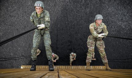 Pvt. Sead Berisha, a psychological operations soldier with the Kosovo Security Force, and Spc. Theresa Haskin, a Story City, Iowa, native and avionic and survivability equipment repairer with Company B, 248th Aviation Support Battalion, Iowa Army National Guard, rappel down a 60-foot tower during an Air Assault course hosted at Camp Dodge in Johnston, Iowa, on Sept. 6, 2022.