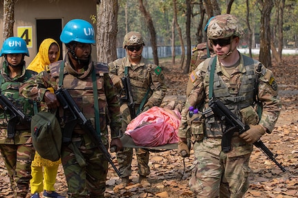 Oregon Army National Guardsmen of 3-116 Cavalry unit, Charlie Company along with a Bangladesh Army counterparts carry a local role player on a litter during cordon and search operations training as part of Exercise Tiger Lightning 2023 at the Bangladesh Institute of Peace Support Operation Training (BIPSOT) center near Dhaka, Bangladesh March 9, 2023.