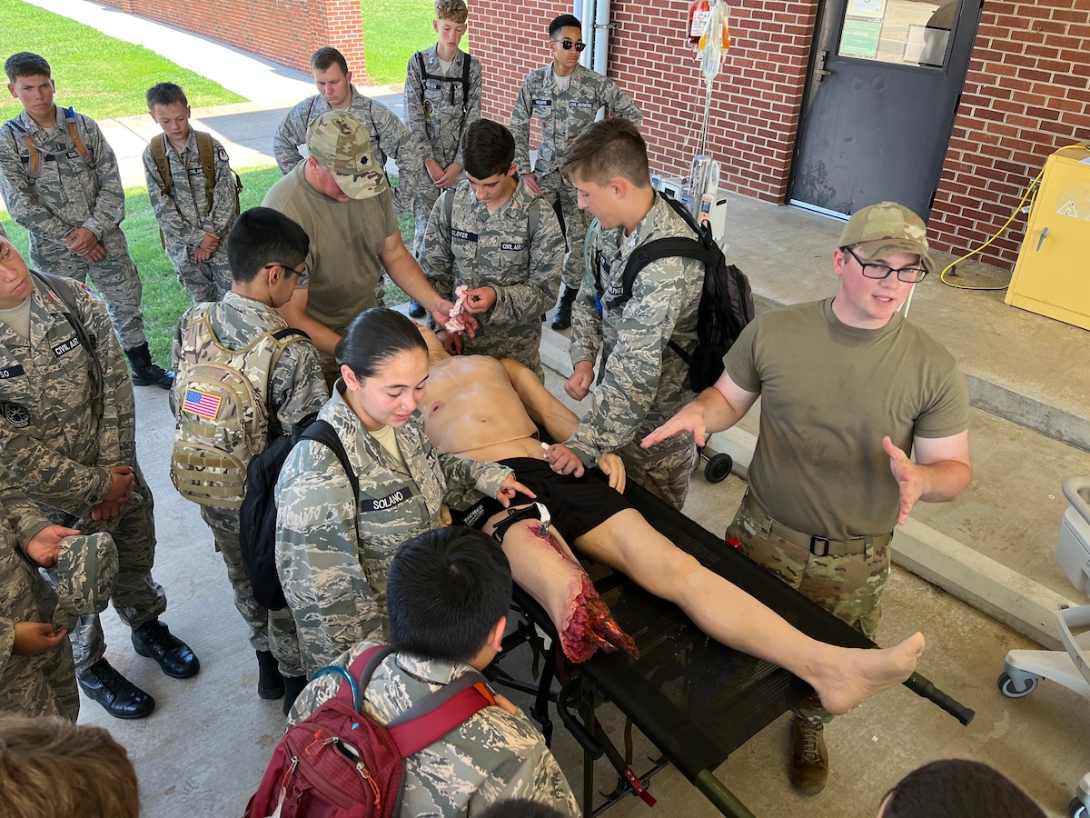 Members of the 188th Med Group show the cadets how to preform tactical combat casualty care on a mannequin.