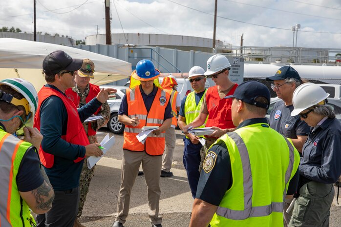 Joint Task Force-Red Hill (JTF-RH) personnel and stakeholder representatives review documents during a spill response exercise on Joint Base Pearl Harbor-Hickam, Hawaii, July 13, 2023