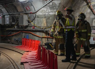 Federal Fire Department personnel discuss response plans during a spill response exercise at the Red Hill Bulk Fuel Storage Facility on Joint Base Pearl Harbor-Hickam, Hawaii, July 13, 2023.