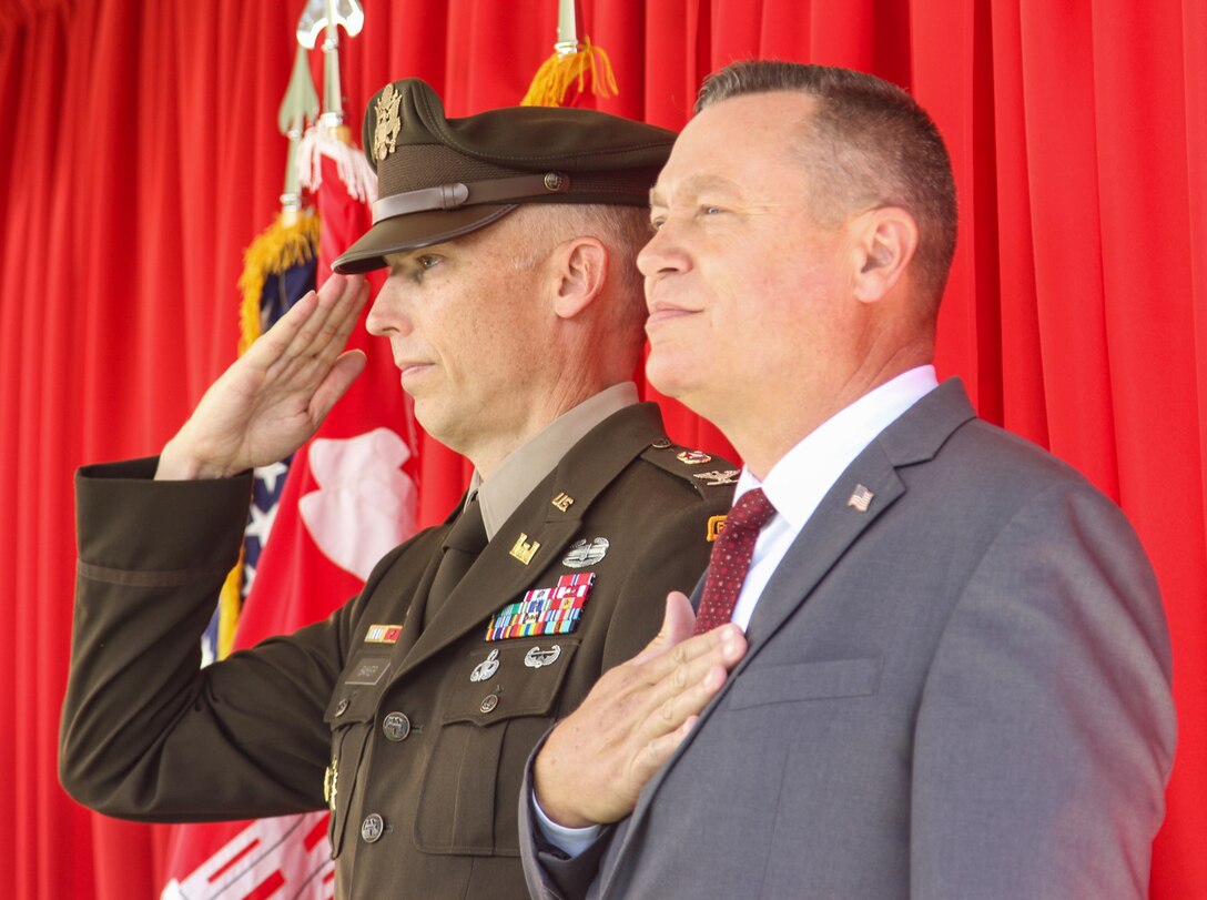 Col. Andrew Baker, incoming commander of the U.S. Army Corps of Engineers Los Angeles District, left, salutes while Justin Gay, LA District deputy district engineer, right, places his hand over his chest during a playing of "The Star-Spangled Banner" at the start of the district’s change of command ceremony July 14, 2023, at the LA District Base Yard in South El Monte, California.
