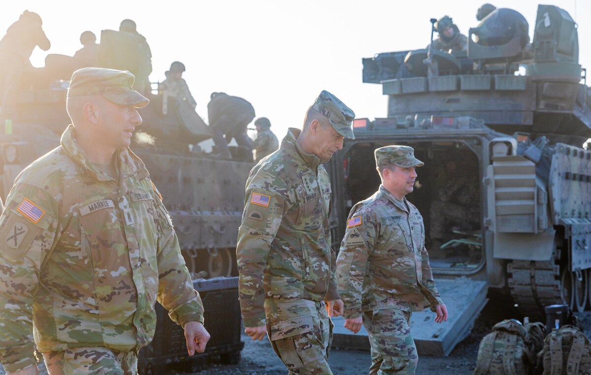 U.S. Army Command Sgt. Maj. Daniel Markle, left, and Col. William Murphy, right, command sergeant major and commander of Task Force Orion, 27th Infantry Brigade Combat Team, New York Army National Guard, walk with Gen. Daniel Hokanson, chief of the National Guard Bureau, through a camp in Grafenwoehr, Germany, March 1, 2023.