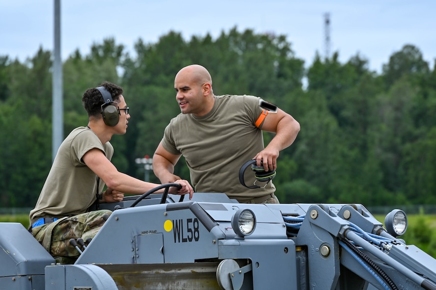 Airman 1st Class Timothy McDonald and Staff Sgt. Julian Montanez, aircraft armaments system technicians from the 69th Bomb Squadron, discuss unloading operations at Joint Base Elmendorf-Richardson, Alaska, July 11, 2023. The maintenance Airmen from the 5th Bomb Wing at Minot Air Force Base, North Dakota, play a key role in ensuring the readiness of the aircraft and assets used in the bomber Agile Combat Employment exercise. (U.S. Air Force photo by Senior Airman Zachary Wright)
