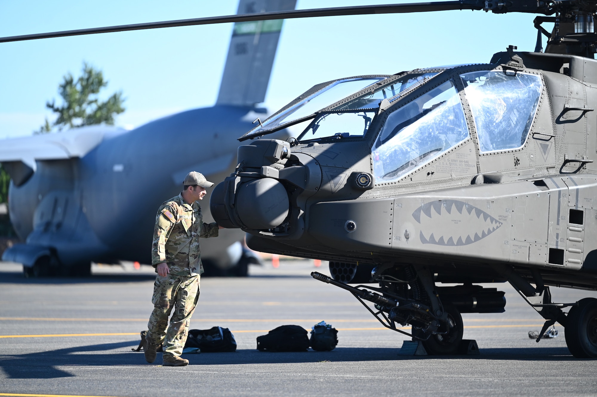U.S. Army Chief Warrant Officer 2 George Smith, an aviation life saving equipment officer with the 1st 229th Attack Battalion 16 CAB, performs post flight checks on an AH-64 Apache helicopter during set up for Joint Base Lewis-McChord’s Airshow and Warrior Expo at JBLM, Washington, July 13, 2023. The mission of the JAWE is to foster goodwill to educate and familiarize attendees with the people, mission, and equipment of the Air Force, Army, and other Armed Services while continuing to provide installation-wide mission support. (U.S. Air Force photo by Senior Airman Colleen Anthony)