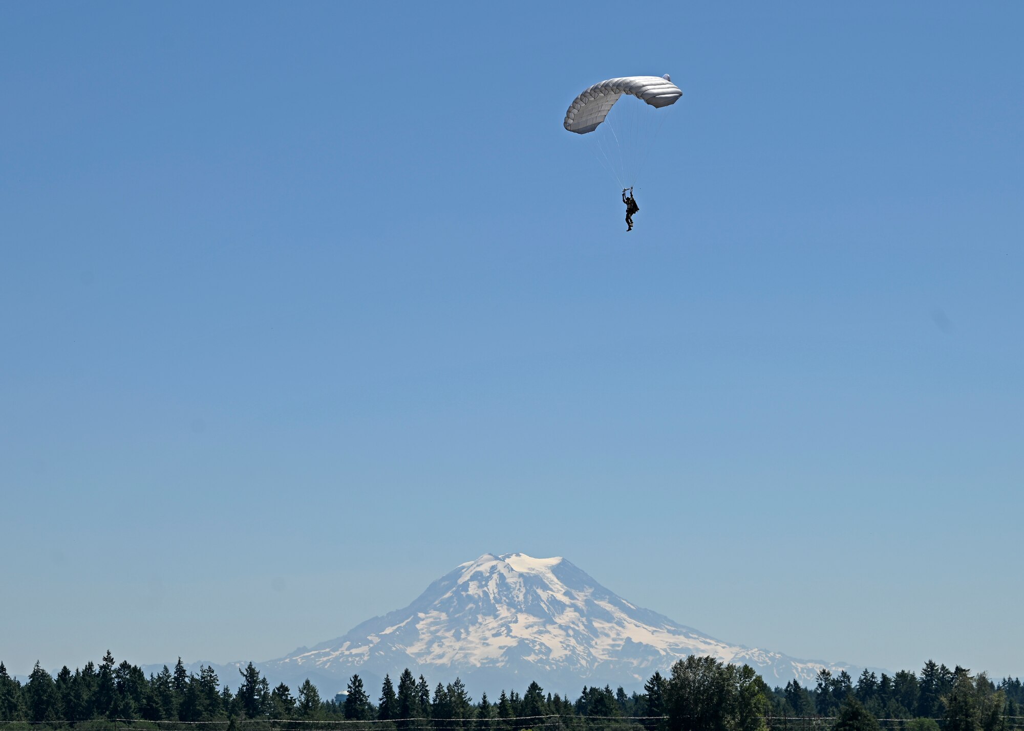 A U.S. Air Force Airman with the 22nd Special Tactics Squadron performs a freefall jump out of a C-17 Globemaster III assigned to the 62d Airlift Wing above the McChord Field flightline in preparation for the Joint Base Lewis-McChord Airshow and Warrior Expo at JBLM, Washington, July 14, 2023. The mission of the JAWE is to foster goodwill to educate and familiarize attendees with the people, mission, and equipment of the Air Force, Army, and other Armed Services while continuing to provide installation-wide mission support. (U.S. Air Force photo by Senior Airman Callie Norton)