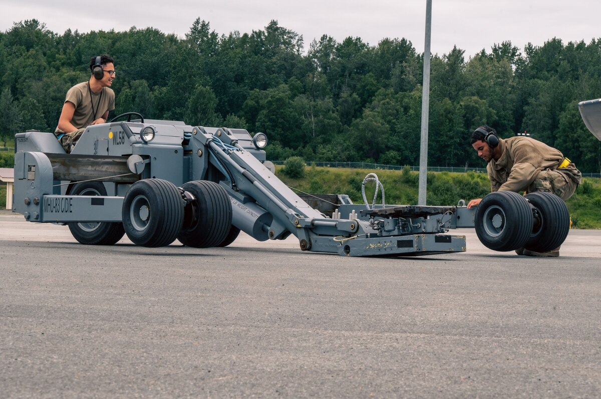 Airman 1st Class Timothy McDonald and Airman 1st Class Jordan Scotland, 69th Bomb Squadron aircraft armament systems technicians, prepare their equipment to unload a B-52H Stratofortress at Joint Base Elmendorf-Richardson, Alaska, July 11, 2023. The Airmen were sent to JBER to maintain the B-52s during a bomber Agile Combat Employment exercise in conjunction with the B-1B Lancer and B-2 Spirit. (U.S. Air Force photo by Senior Airman Evan Lichtenhan)