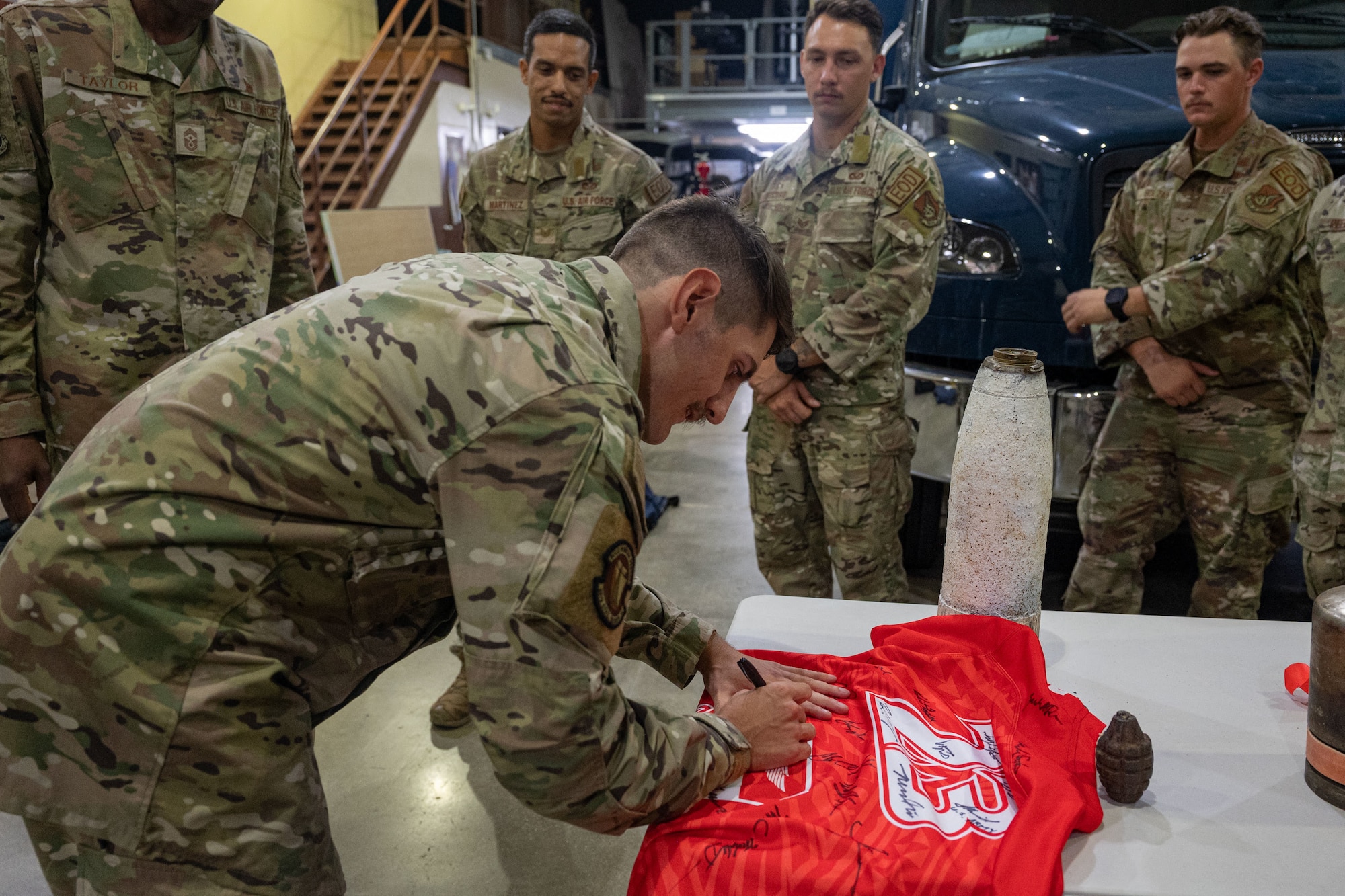 Photo of an Airman signing the official Linebacker of the Week jersey