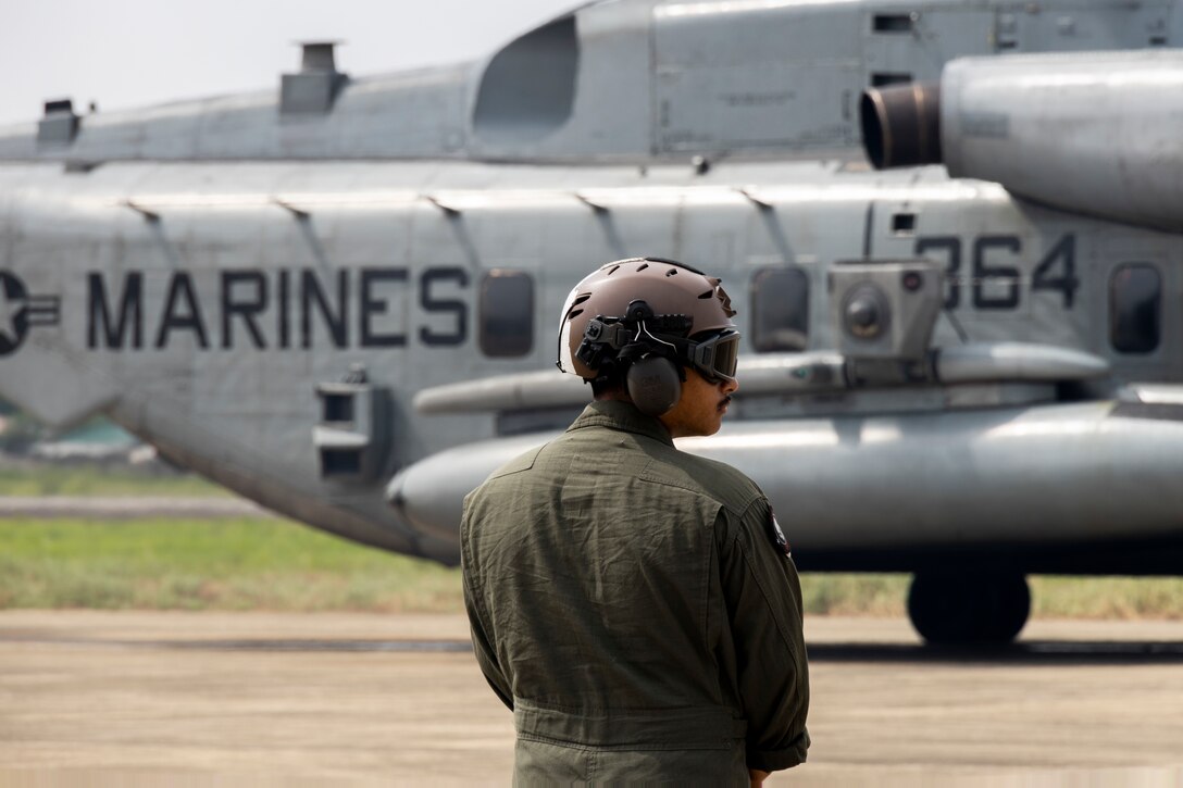 U.S. Marine Corps Sgt. Emilio Perez, an CH-53E flight line mechanic with Marine Medium Tiltrotor Squadron (VMM) 163 (Reinforced), Marine Aircraft Group 16, 3rd Marine Aircraft Wing, waits as the CH-53E Super Stallions prepare to take off from Antonio Bautista Air Base in support of Marine Aviation Support Activity (MASA) 23 events in Puerto Princesa, Palawan, Philippines, July 12, 2023. MASA is a bilateral exercise between the Armed Forces of the Philippines and the U.S. Marine Corps, aimed at enhancing interoperability and coordination focused on aviation-related capabilities. During MASA 23, Filipino and U.S. Marines conduct different training evolutions, including live-fire, air assaults, and subject matter expert exchanges across aviation, ground, and logistics capabilities. Perez is a Los Angeles native. (U.S. Marine Corps photo by Cpl. Sean A. Potter)