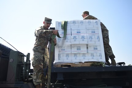 U.S. Army Private 1st Class Daban Falah (left), and Spc. Nicholas Audet, both truck drivers, Alpha Company, 186th Brigade Support Battalion, 86th Infantry Brigade Combat Team (Mountain), Vermont Army National Guard, secure drinking water supplied by FEMA, Berlin, Vt., July 13, 2023.