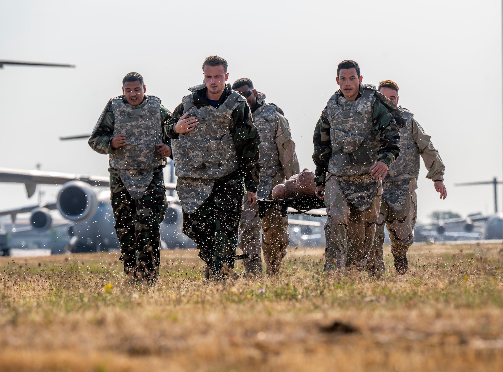 Members of the 940th Squadron, Royal Netherlands Air Force, perform a litter carry while under a simulated attack using water balloons during the 521st Air Mobility Operations Wing’s Mobility Rodeo at Ramstein Air Base, Germany, July 11, 2023.