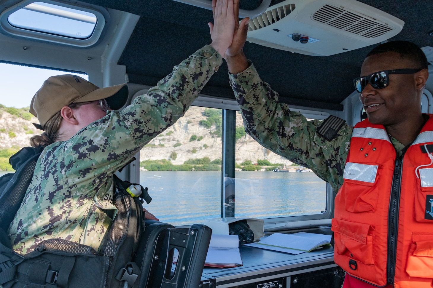 From left to right, Master-at-Arms 3rd Class Baily Shaw, assigned to Naval Support Activity Souda Bay, and Ensign Andrae White, security officer, NSA Souda Bay, high five after a successful Swimmer Attack Drill as part of an Antiterrorism Training Team Exercise at the NATO Marathi Pier Complex on July 11, 2023. NSA Souda Bay’s Navy Security Force works 24 hours a day, seven days a week and 365 days a year to safeguard personnel and prevent unauthorized access to equipment, installations, materiel and documents to protect against espionage, sabotage, damage and theft.