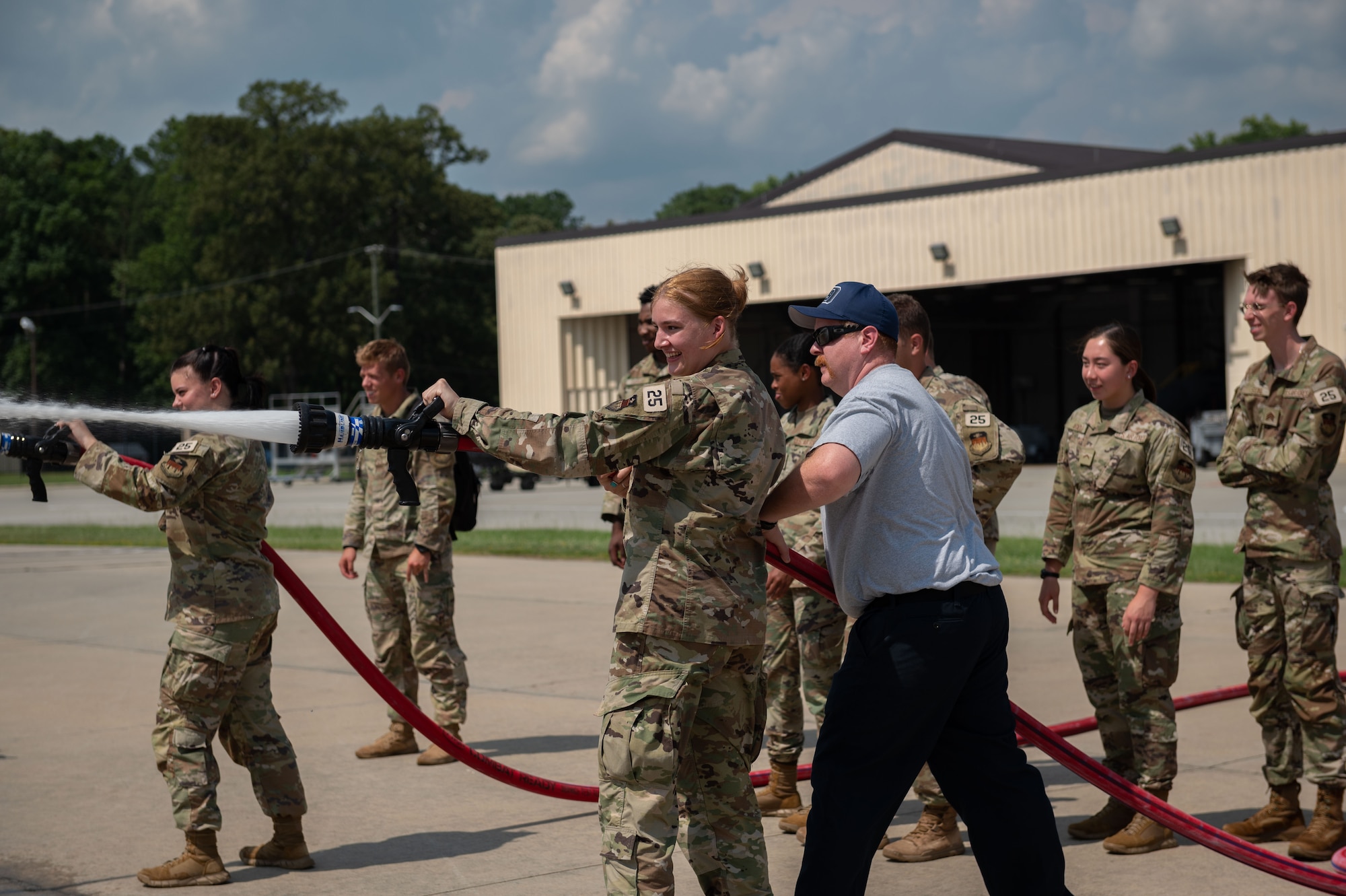 U.S. Air Force Academy cadets learn how to use a fire hose during an Operation Air Force visit at Seymour Johnson Air Force Base, North Carolina, July 8, 2023. Military education and hands on visit help to play a critical role in preparing cadets to become leaders in the cadet wing and later in the Air Force and Space Force. (U.S. Air Force photo by Airman 1st Class Rebecca Sirimarco-Lang)