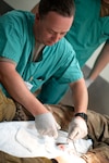 U.S. Air Force Staff Sgt. Lee Hunter, a medical technician assigned to the Ohio National Guard’s 180th Fighter Wing, sutures a laceration on a patient at U.S. Naval Hospital Okinawa, Japan, JUly 17, 2023.