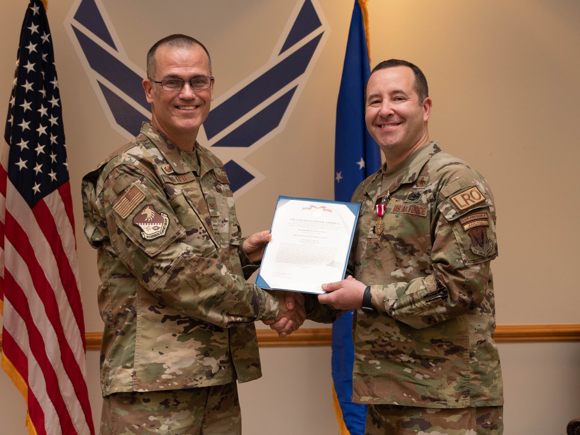 Col. Todd Walker, 4th Mission Support Group commanders, awards Lt. Col. Robert Fekete with the meritorious service medal during a change of command ceremony at Seymour Johnson Air Force Base, July 14, 2023. The ceremony was conducted to commemorate the passing of command of the 4th Logistics Readiness Squadron from Fekete to Maj. Lovell C.K. Davis Jr. (U.S. Air Force photo by Staff Sgt. Koby I. Saunders)