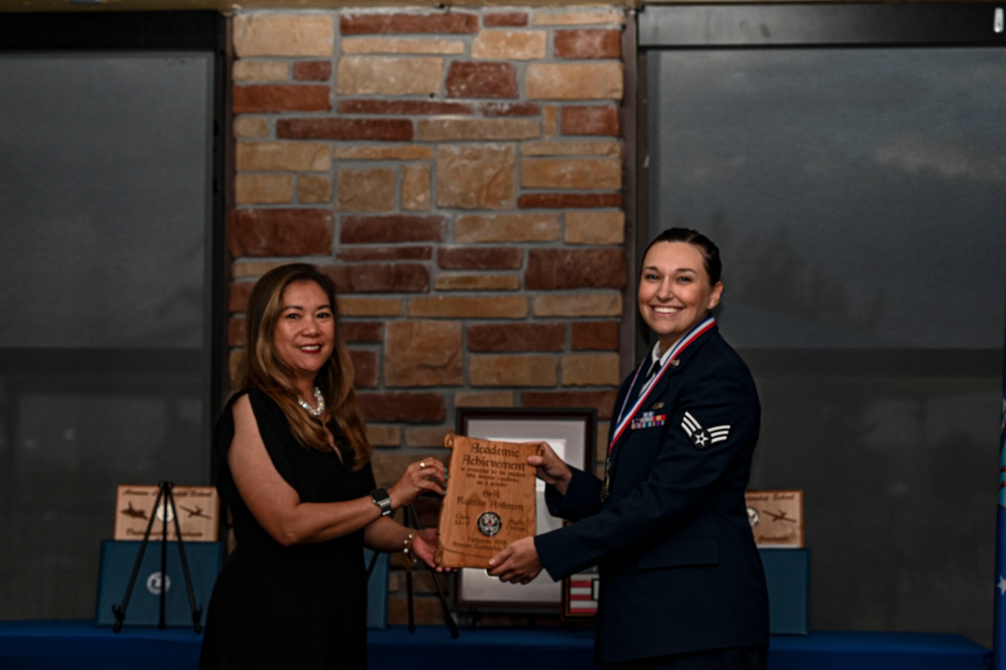 U.S. Air Force Senior Airman Kaitlin Ankrom, Airman Leadership School graduate, right, receives the Academic Achievement Award during the graduation of ALS class 23-F at Holloman Air Force Base, New Mexico, July 14, 2023. The academic award is presented to the student with the highest overall average on all academic evaluations and demonstrations of leadership. (U.S. Air Force photo by Airman 1st Class Isaiah Pedrazzini)