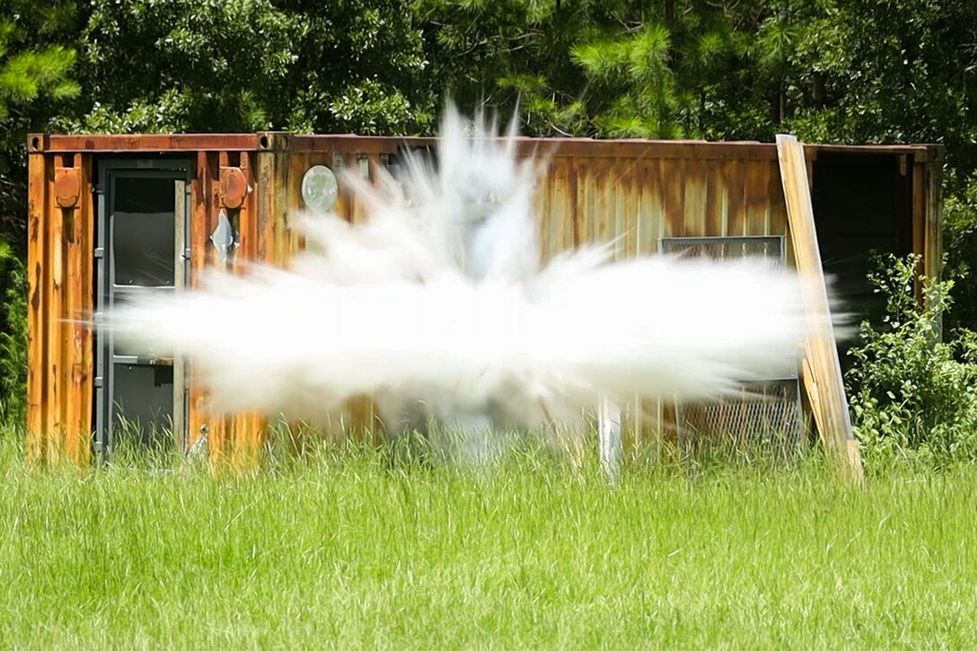A breaching charge explodes at an outdoor training course.