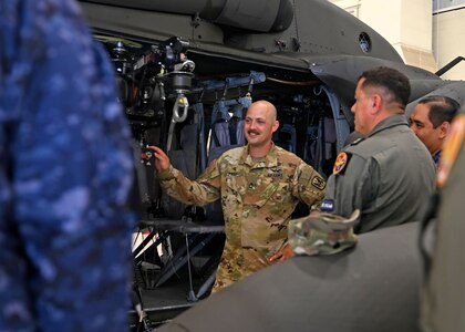 Sgt. 1st Class Keith Page, a production controller with Alpha Company, 1-169th Aviation Regiment, leads a discussion with seven military guests from El Salvador Black Hawk hoist operation and rescue techniques at the Army Aviation Support Facility on July 11 in Concord.