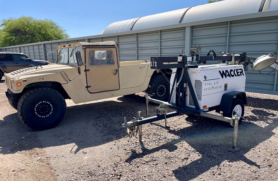 A Humvee is parked outside an industrial building.