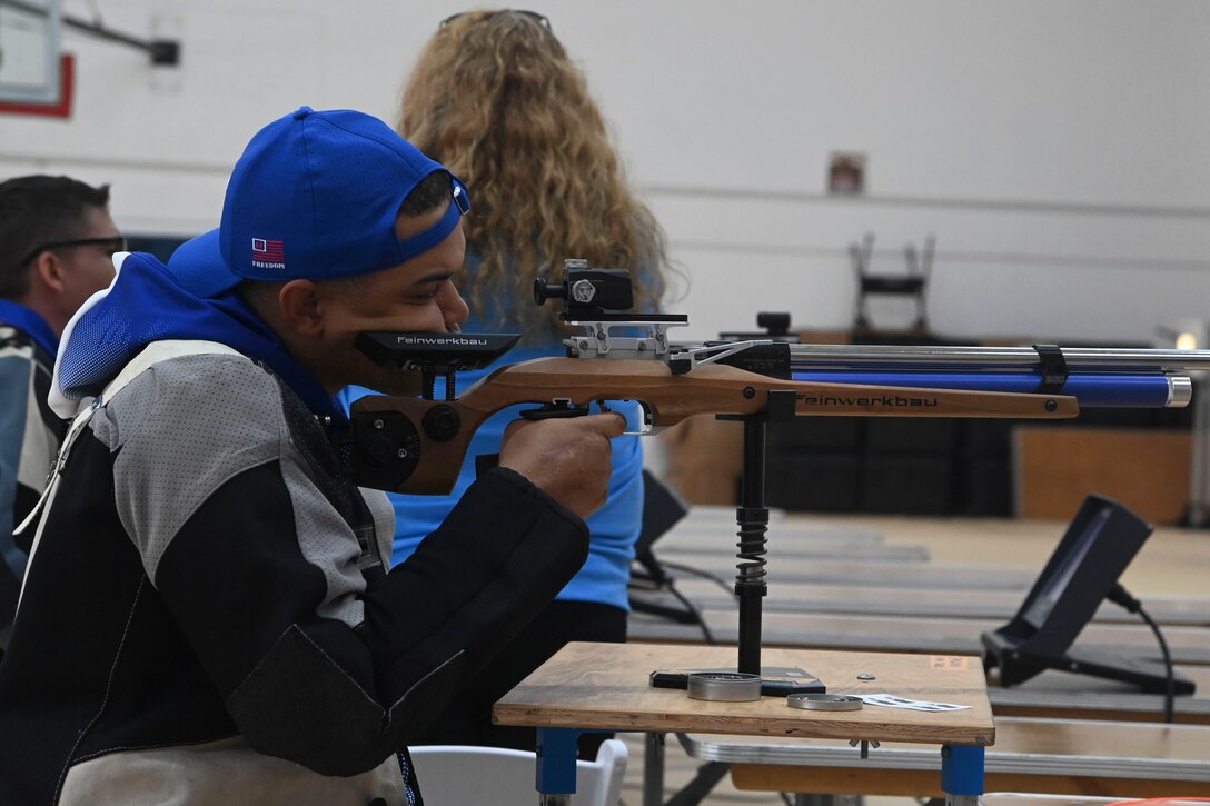 A man aims an air rifle at a target.